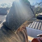 A man covered in sawdust from cutting a tree