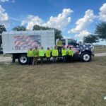 A Matt Tree Service crew member in yellow shirts standing in front of white work truck