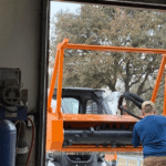 Forestry mulcher machine with man in blue shirt standing in front of it